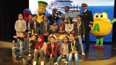 AIDA Cruises überreicht RTL - Wir helfen Kindern und Projektpate Sasha einen Spenden-Scheck in Höhe von 100.000 Euro.