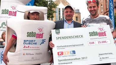 sebamed Sportmarketing Manager Toni Neier überreicht Tom Lehel den sebamed Spendenscheck in Höhe von 25.000 EUR.