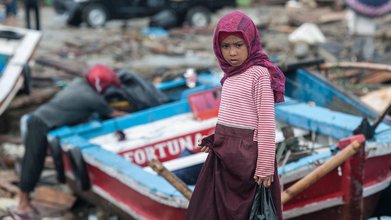 24.12.2018, Indonesien, Pandeglang: Ein Mädchen steht nach einem Tsunami in den Trümern einer Ortschaft. Ein Tsunami entlang der Küstengebiete der Sunda-Straße zwischen Java und den Sumatra-Inseln hat mehr als 370 Menschen getötet. Foto: Veri Sanovri