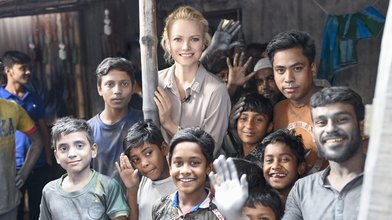 Franziska Knuppe umgeben von Kindern in einer Aluminiumfabrik in Bangladesch.